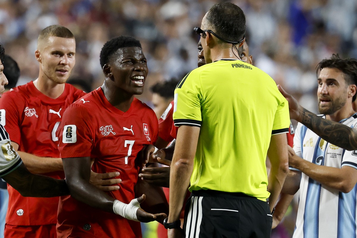 Switzerland's Breel Embolo, left, reacts after referee Joao Pedro Silva Pinheiro, right, sends him off the field with a red card after VAR intervention during the World Cup quarter final match be ...