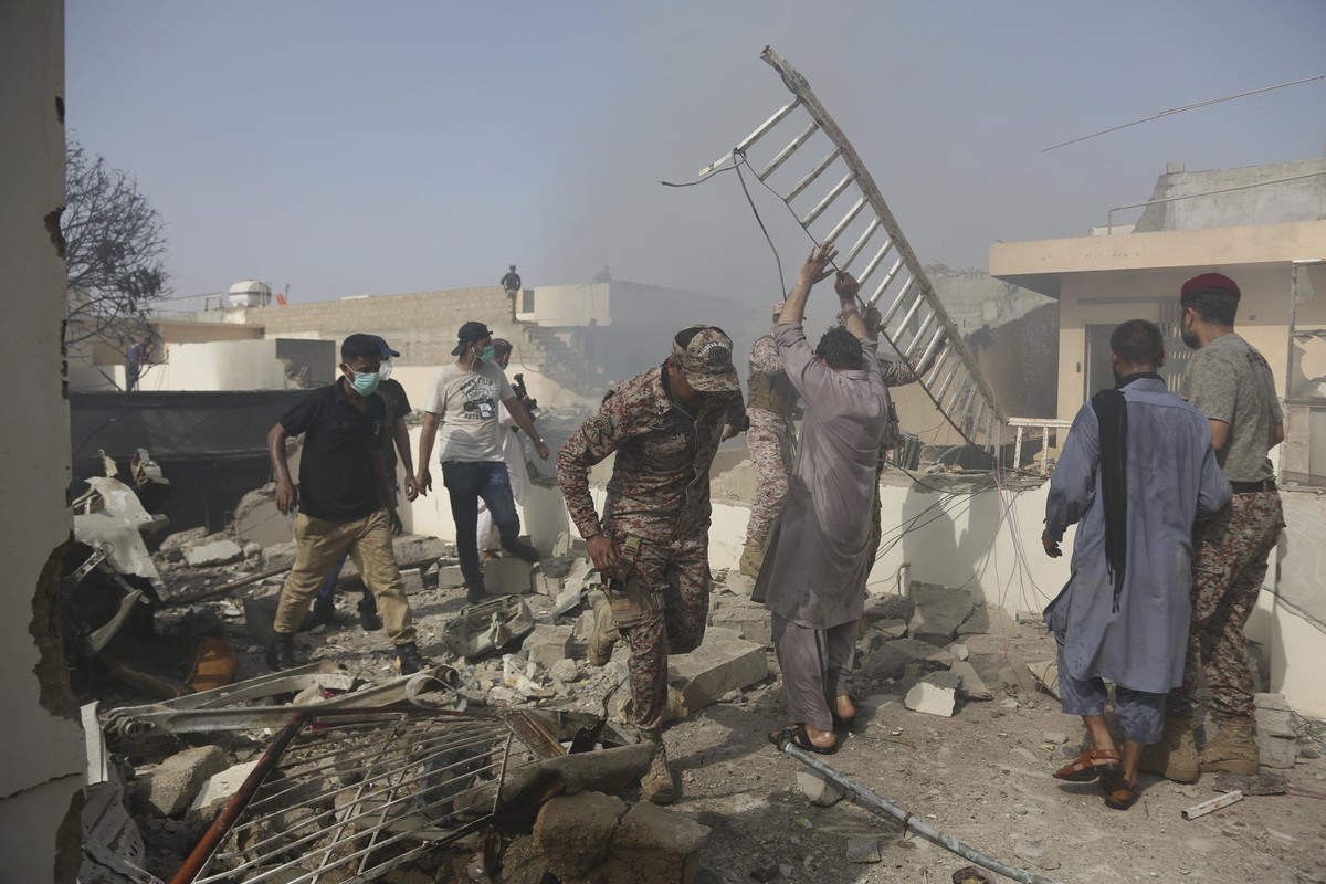 Rescue work is in progress at the site of a plane crash in Karachi, Pakistan, Friday, May 22, 2020. An aviation official says a passenger plane belonging to state-run Pakistan International Airlines c ...