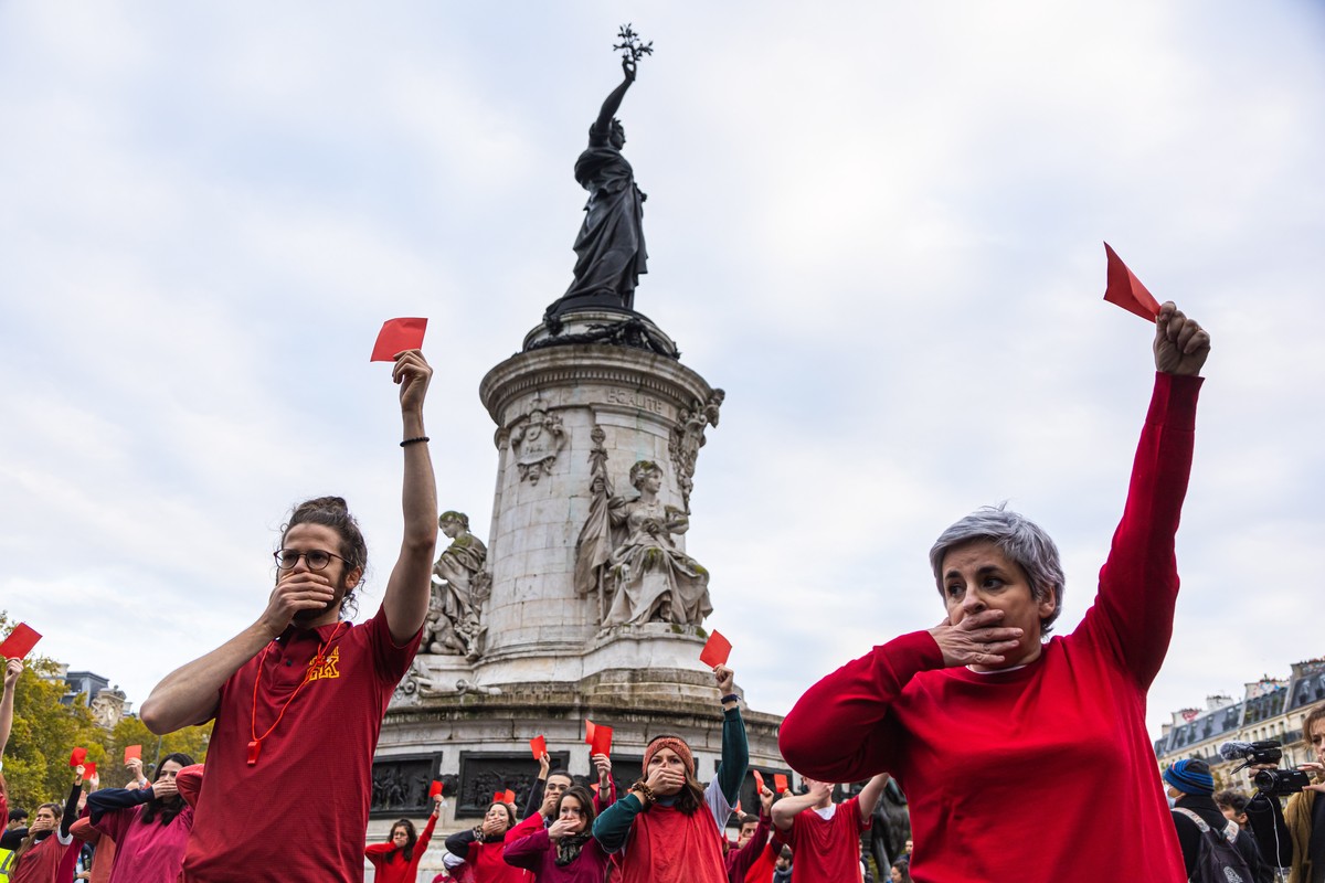 epa10316208 Members of the French environmental activists named 'Red Card to Qatar' show Red Cards, as they gather to perform a die-in at Republic square in Paris, France, 20 November 2022.  ...