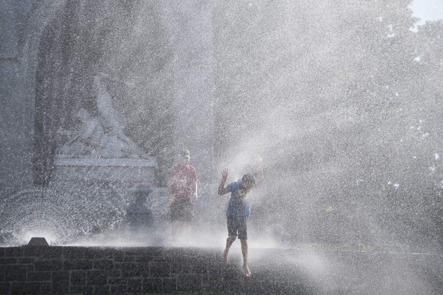 Kinder geniessen das kuehle Nass einer Wasserspritze vor dem Winkelried Denkmal auf dem Dorfplatz in Stans anlaesslich der Jubilaeumsfeier 125 Jahre Wasserversorgung Stans am Sonntag 1. Juli 2018. (KE ...