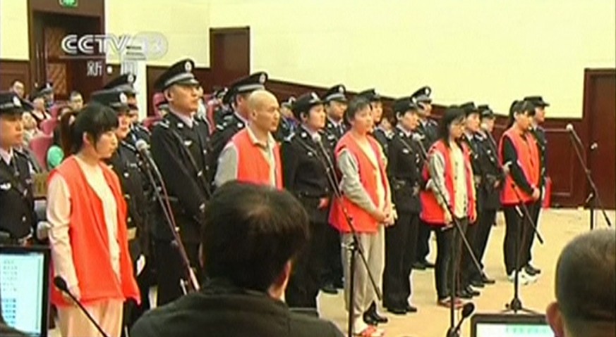Die Sektenmitglieder mit Polizeieskorte während der Gerichtsverhandlung.