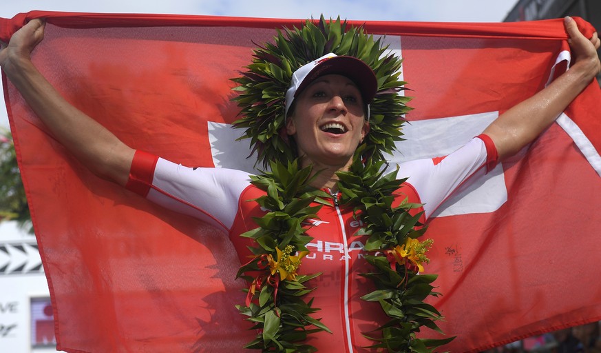 Daniela Ryf, of Switzerland, holds up her country&#039;s flag after winning the women&#039;s group of the Ironman World Championship Triathlon, Saturday, Oct. 8, 2016, in Kailua-Kona, Hawaii. (AP Phot ...