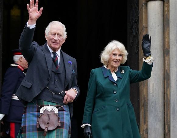 Britain&#039;s King Charles III and Camilla, the Queen Consort, wave as they leave Dunfermline Abbey, after a visit to mark its 950th anniversary, and after attending a meeting at the City Chambers in ...