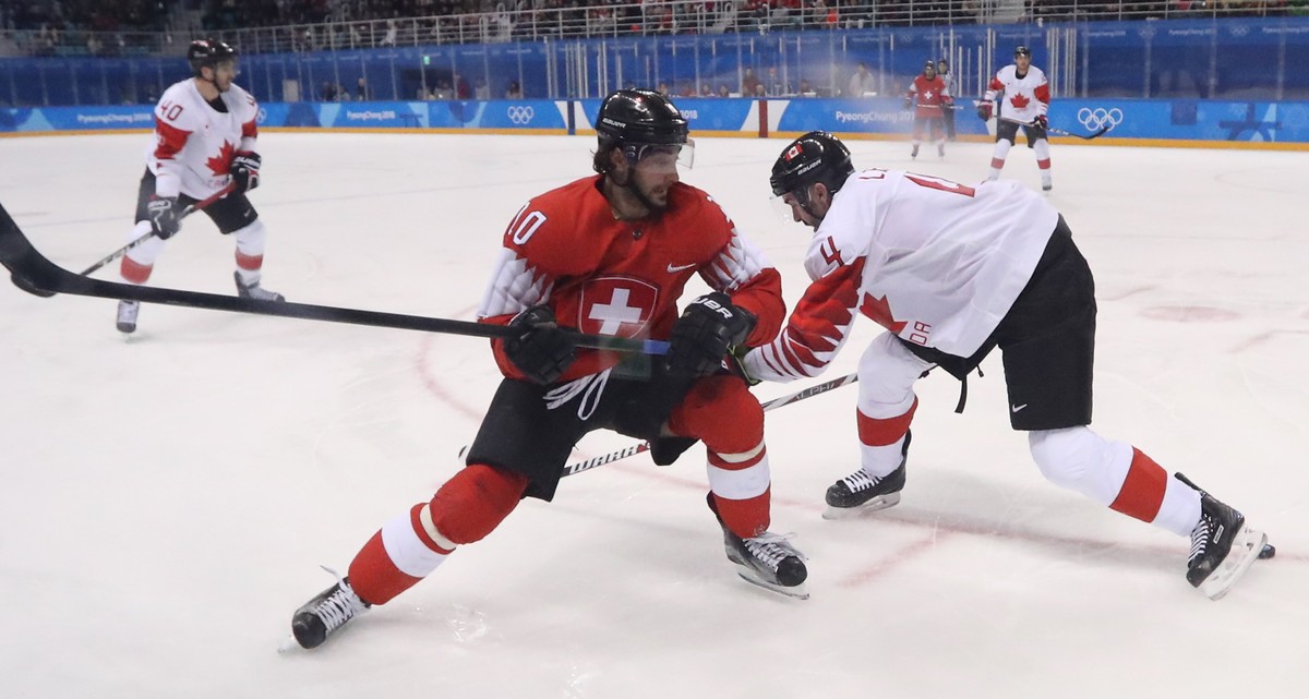 epa06528778 Andres Ambuhl (L) of Switzerland in action against Chris Lee of Canada during the men's Ice Hockey preliminary round match between Switzerland and Canada at the Kwandong Hockey Centre ...