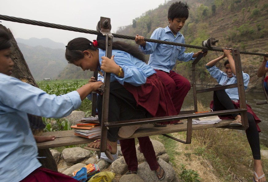 Schoolchildren Aasrang village of Chainpur village in Lalipur district , some 75 Kilometer south east from capital Kathmandu, making the risky crossing of the Bagmati River with the use of the Tuin (r ...