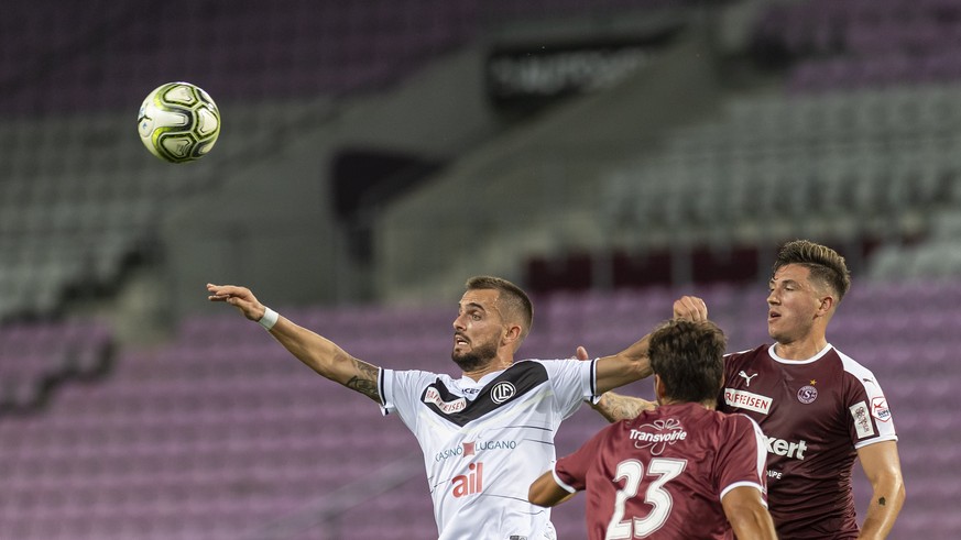 Le joueur de Lugano Filip Holender, gauche, lutte pour le ballon contre deux joueurs de Servette Vincent Sasso, centre, Christopher Routis, droite, lors de la rencontre de football de Super League ent ...