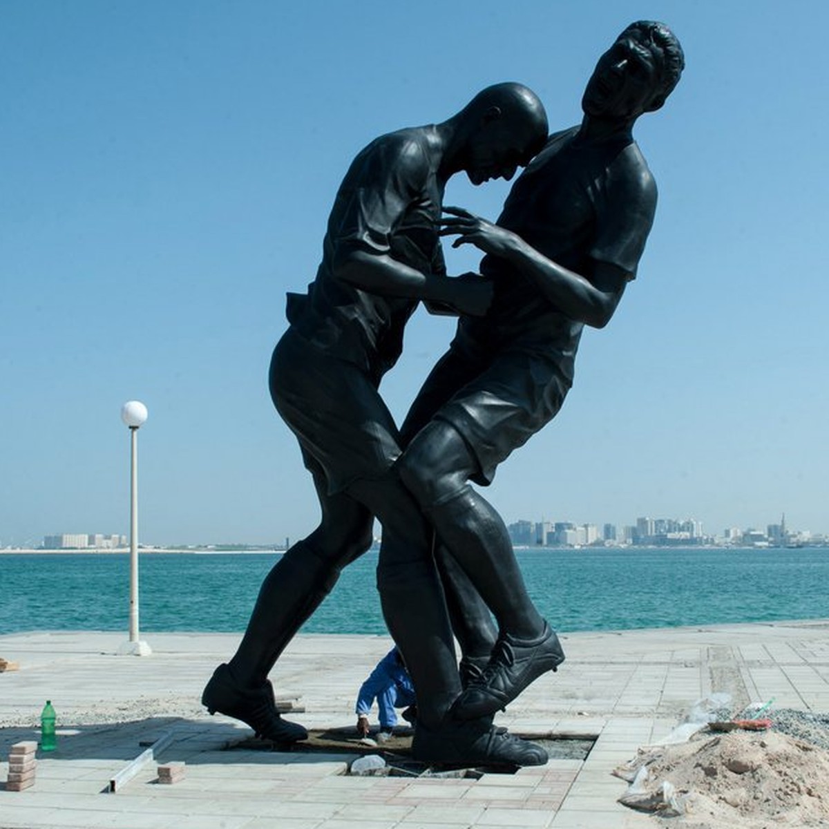 epa03895867 Workers install a five-meter-tall bronze statue of former French soccer international Zinedine Zidane's famous head-butt at the corniche of Doha, Qatar, 04 October 2013. The sculpture ...