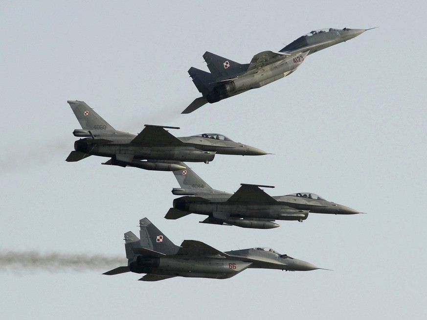 FILE - Two Polish Air Force Russian made Mig 29&#039;s fly above and below two Polish Air Force U.S. made F-16&#039;s fighter jets during the Air Show in Radom, Poland, on Aug. 27, 2011. In a private  ...