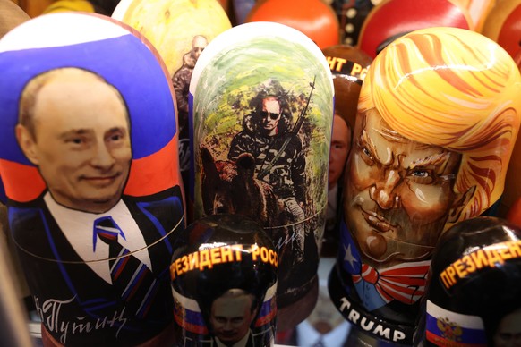 epa12294026 Traditional Russian wooden Matryoshka dolls depicting Russian President Vladimir Putin (L) and US President Donald Trump (R) on display for sale at a souvenir market in Moscow, Russia, 11  ...