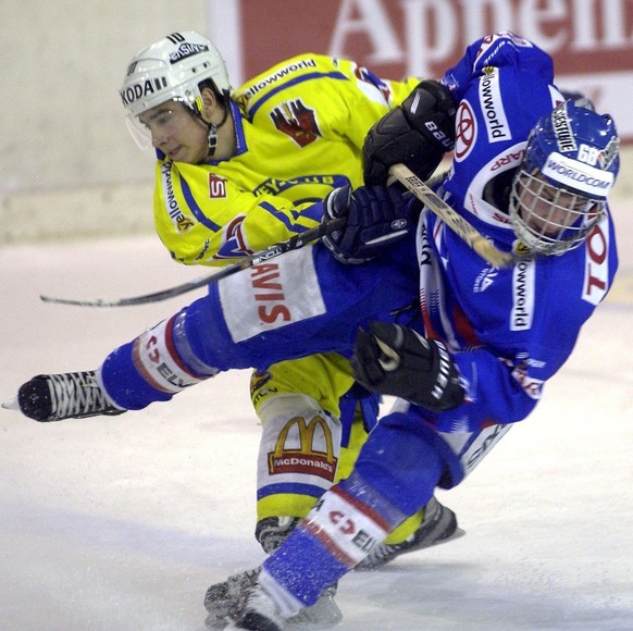 Der Davoser Andres Ambuehl, links, im Zweikampf mit Klotens Cyrill Buehler, rechts, im Spiel der Eishockey NLA des HC Davos gegen die Kloten Flyers, am Samstag, 13. Oktober 2001, in der Davoser Eishal ...