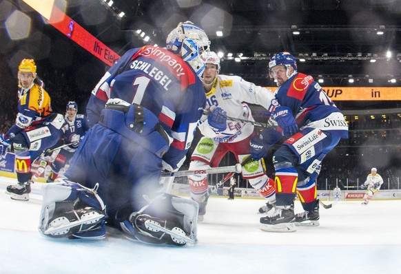 EHC Kloten Stuermer Daniele Grassi, Mitte, schiesst das 2-1 gegen ZSC Lions Torhueter Niklas Schlegel und Mathias Seger, rechts. waehrend dem Eishockey-Meisterschaftsspiel der National League zwischen ...