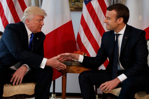 FILE - In this May 25, 2017 file photo, US President Donald Trump, shakes hands with French President Emmanuel Macron, right, during a meeting at the U.S. Embassy in Brussels. Macron arrives Monday Ap ...