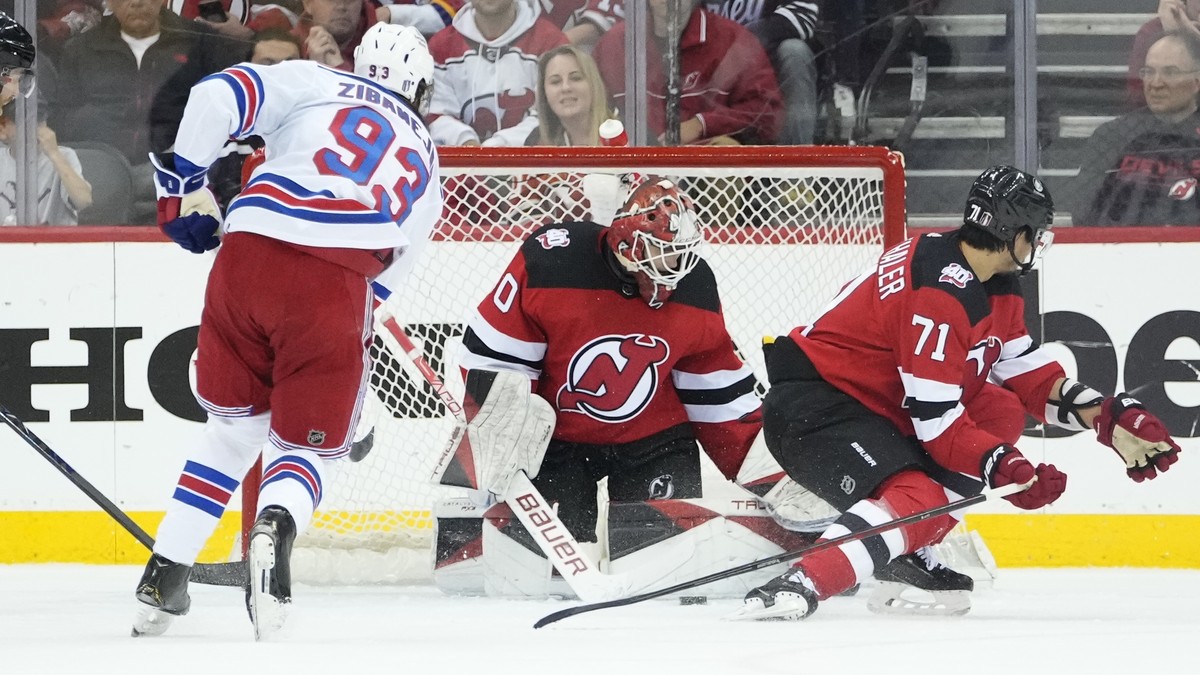 New Jersey Devils goaltender Akira Schmid (40) stops a shot by New York Rangers' Mika Zibanejad (93) during the second period of Game 5 of an NHL hockey Stanley Cup first-round playoff series Thu ...