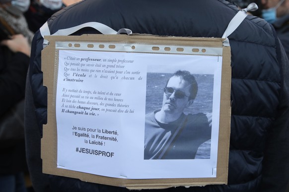 A demonstrator displays on his back a portrait of slain teacher Samuel Paty during a demonstration Sunday Oct. 18, 2020 in Paris. Demonstrations around France have been called in support of freedom of ...