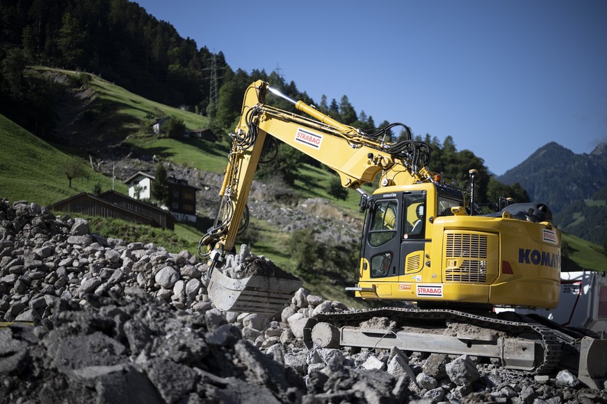 Ein Bagger fuehrt Steine ab, im Hintergrund die Wagenrunse, aufgenommen am Dienstag, 27. August 2024, in Schwanden. Vor einem Jahr hat sich ein Erdrutsch mit 30&#039;000 Kubikmeter Geroell und seither ...