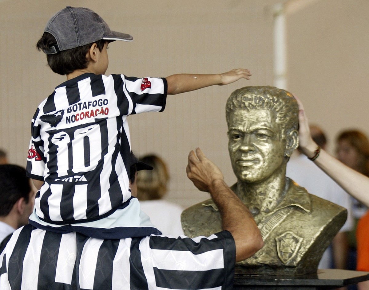 A young supporter of Brazilian team Botafogo touches the statue of Garrincha at Maracana stadium in Rio de Janeiro. A young supporter of Brazilian team Botafogo touches the statue of Mane Garrincha, t ...