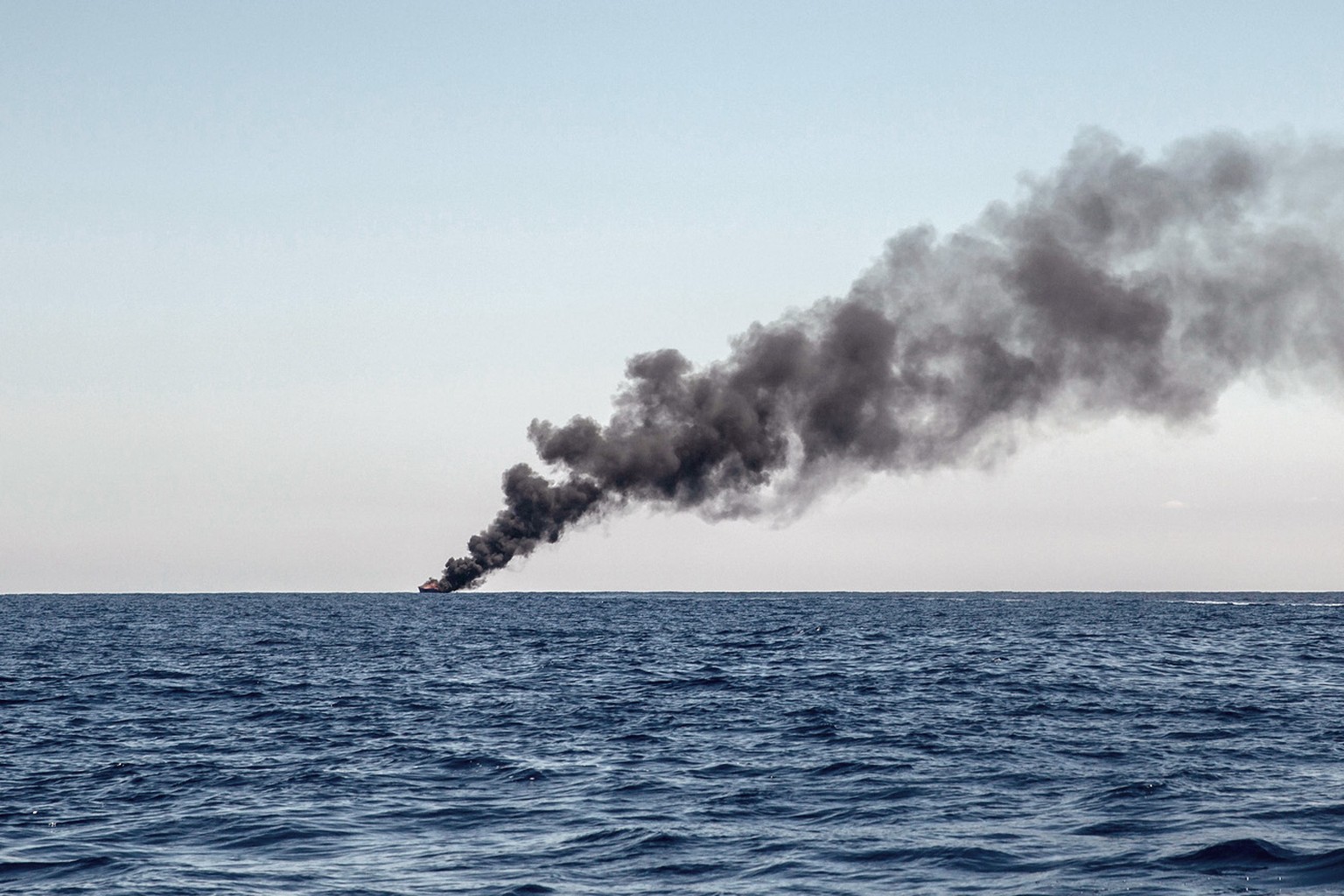 A wooden boat, on which around 1,000 refugees and migrants were trying to cross the Mediterranean Sea from Libya to Italy, is seen being burned by the Italian army after all its passengers had been tr ...