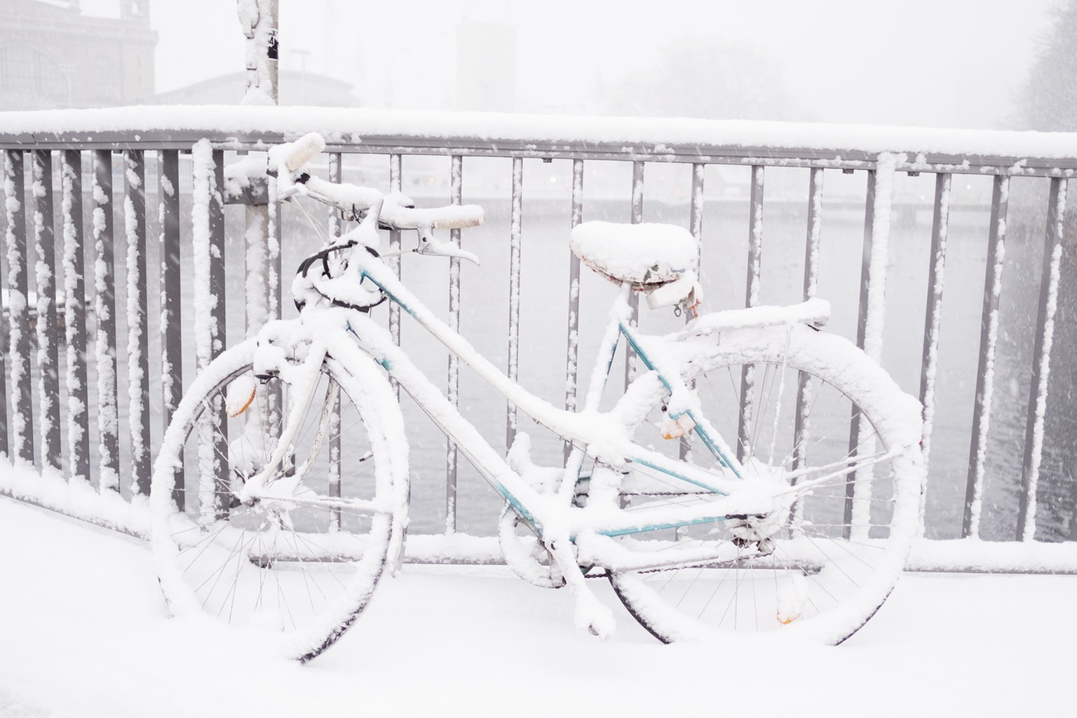Ein mit Schnee bedecktes Fahrrad abgeschlossen am Gelaender der Bahnhofquaibruecke, aufgenommen am Montag, 18. Dezember 2017, in Zuerich. (KEYSTONE/Petra Orosz)