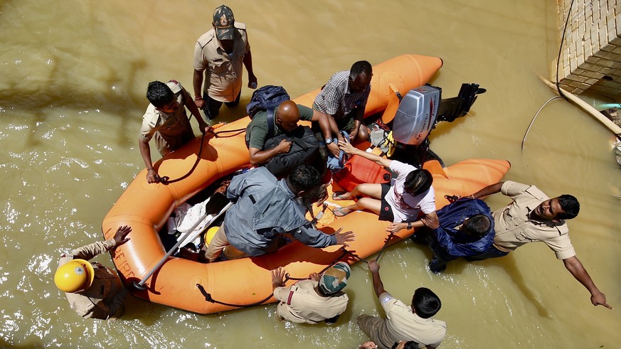 epa10161582 Firefighters use an inflatable boat as they rescue the residents of the flooded areas following overnight heavy rainfall, in Bangalore, India, 05 September 2022. According to Karnataka Sta ...