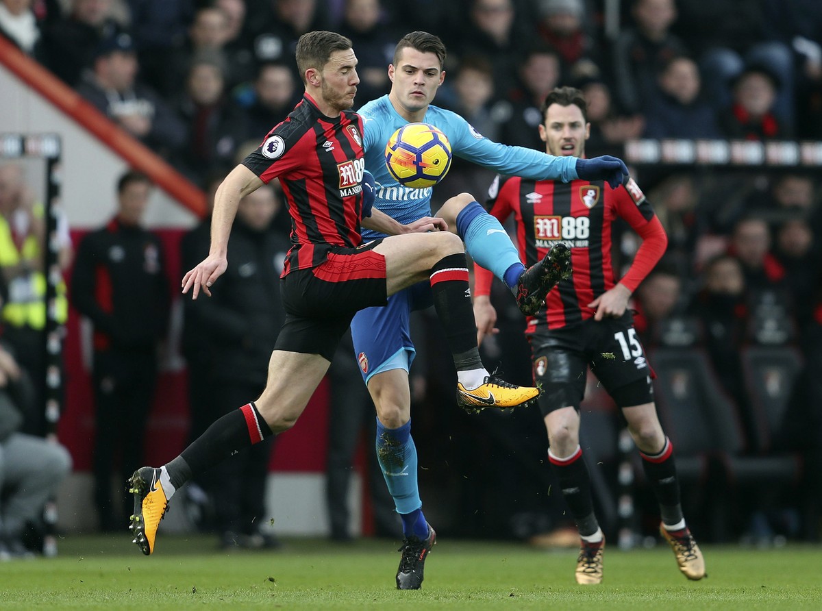 Arsenal's Granit Xhaka, center, is challenged by Bournemouth's Dan Gosling during the English Premier League soccer match against Bournemouth at the Vitality Stadium, Bournemouth, England, S ...