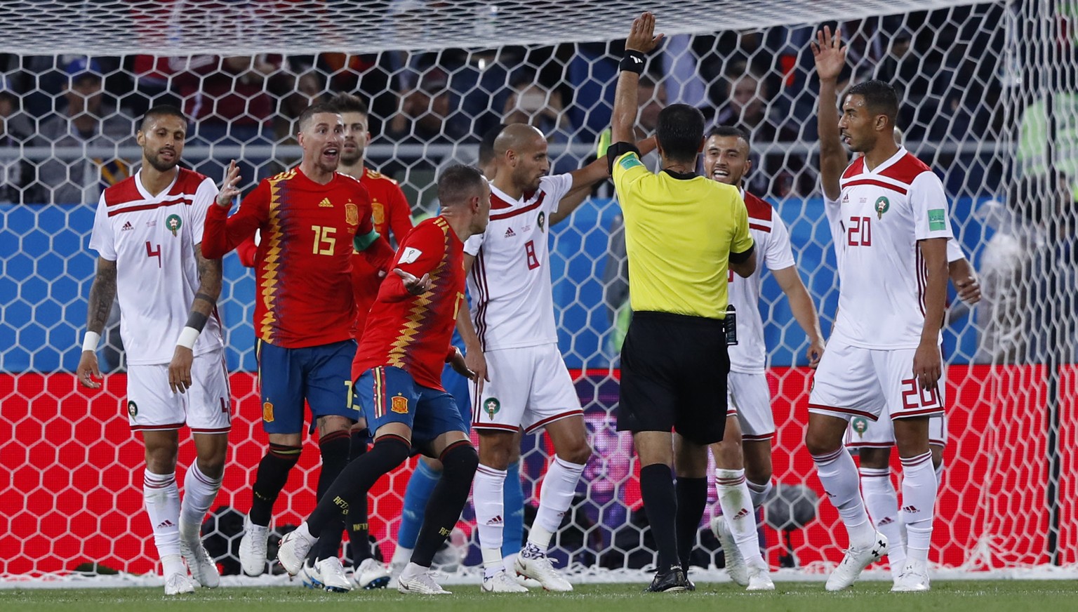 Players of Spain and Morocco argue to referee Ravshan Ermatov during the group B match between Spain and Morocco at the 2018 soccer World Cup at the Kaliningrad Stadium in Kaliningrad, Russia, Monday, ...