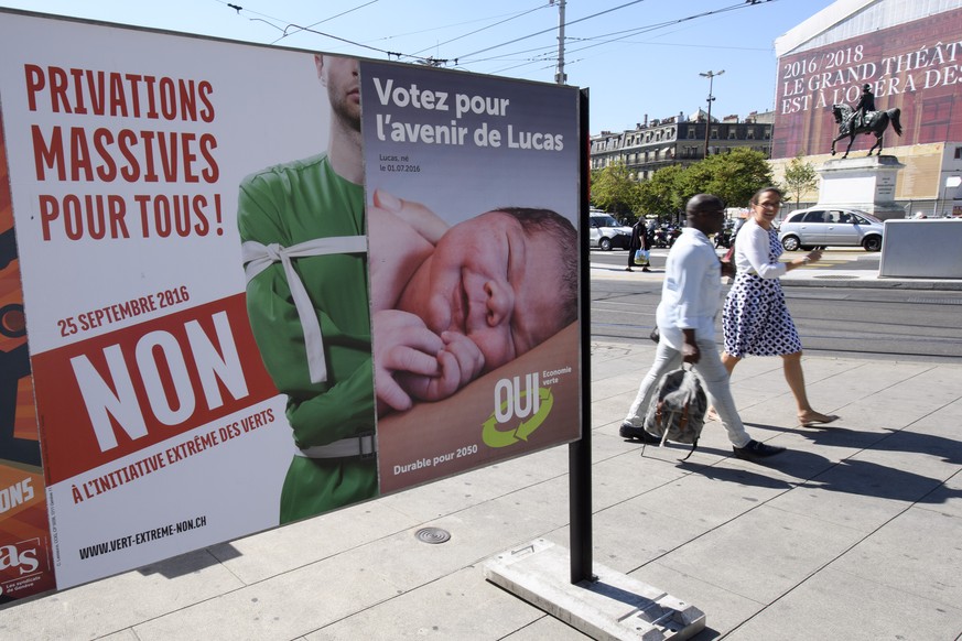 Des personnes passen devant des affiches sur les differents themes des votations federales et cantonales, les initiative populaire, pour une economie durable et fondee sur une gestion efficiente des r ...