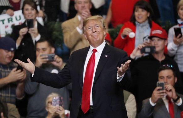 President Donald Trump gestures as he acknowledges the fake snow that fell as he entered the Mississippi Coast Coliseum for a rally Monday, Nov. 26, 2018, in Biloxi, Miss. (AP Photo/Rogelio V. Solis)