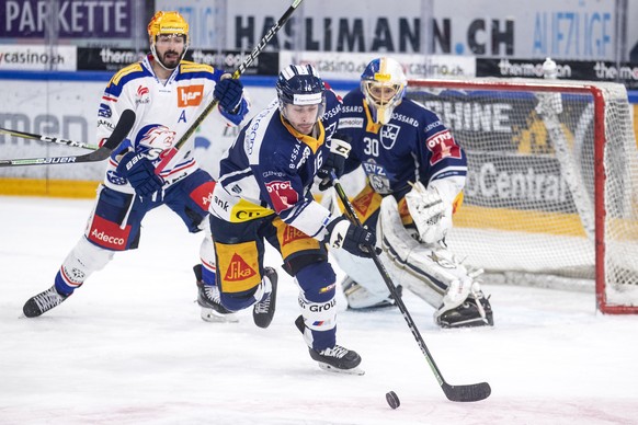 Zuerichs Denis Hollenstein, Zugs Raphael Diaz und Zugs Torhueter Leonardo Genoni, von links, im Eishockey Spiel der National League zwischen dem EV Zug und den ZSC Lions am Dienstag, 26. Januar 2021,  ...