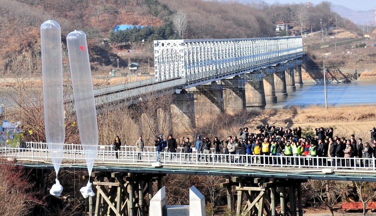 epa01637387 Members of two local civic groups release balloons carrying anti-North Korean leaflets and North Korean 5,000-won bills from the Freedom Bridge in a stunt carried out in the South Korean b ...