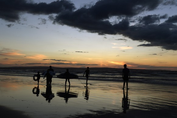 epaselect epa08592956 Swimmers and surfers pictured at sunset on Enniscrone Beach in County Sligo on the West coast of Ireland on 08 August 2020 (issued 09 August 2020. The Irish governemnt announced  ...