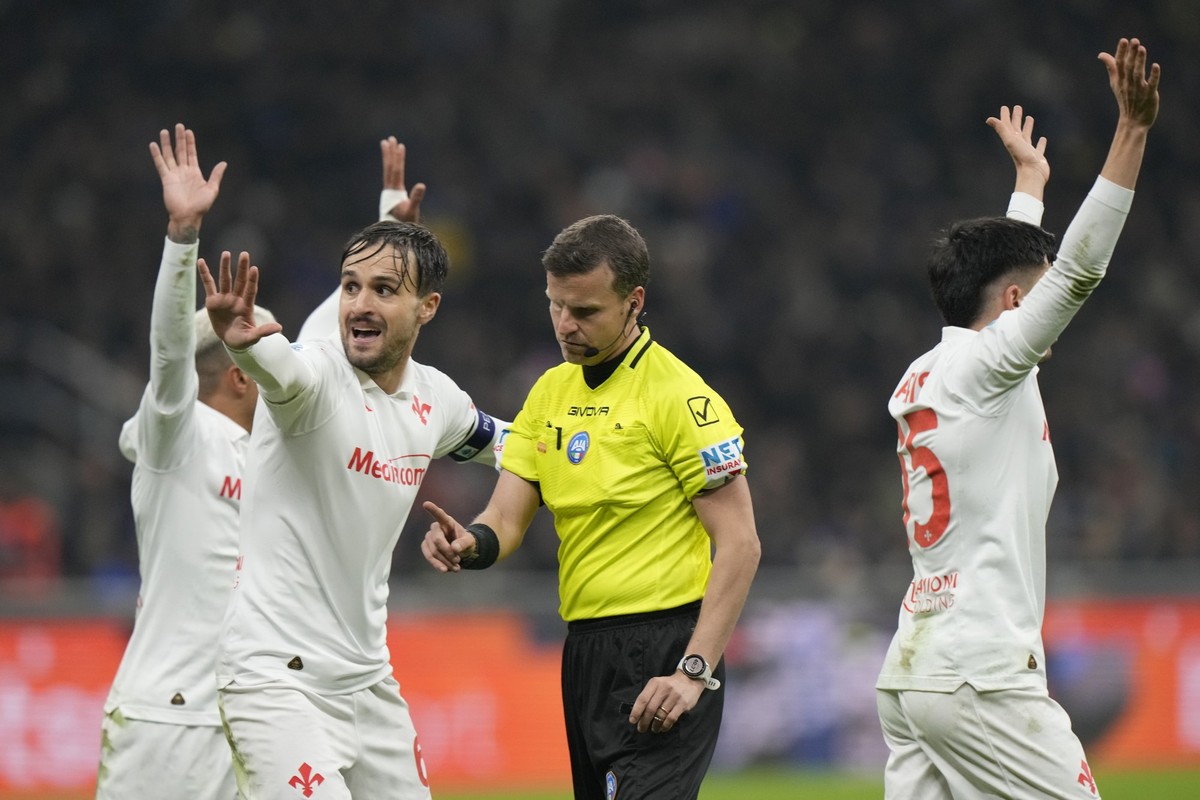 Fiorentina's Luca Ranieri, left, argues with referee Federico La Penna during the Serie A soccer match between Inter Milan and Fiorentina at the San Siro stadium, in Milan, Italy, Monday, Feb. 10 ...