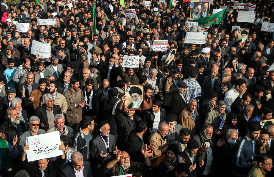 epa06410142 Iranians hold portraits of Iranian supreme leader Ayatollah Ali Khamenei and chant slogans as they take part in a rally to support the government and regime, outside of the Imam Khomeini g ...