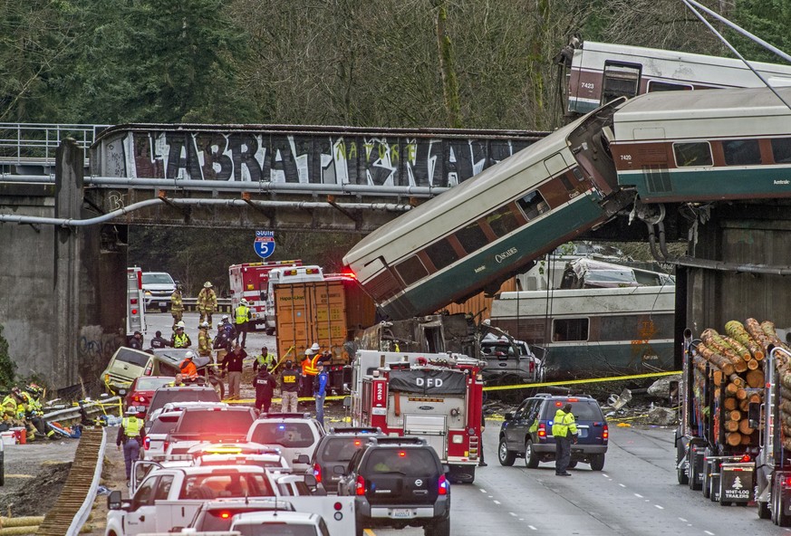 Cars from an Amtrak train that derailed lie spilled onto Interstate 5, Monday, Dec. 18, 2017, in DuPont, Wash. The Amtrak train making the first-ever run along a faster new route hurtled off the overp ...