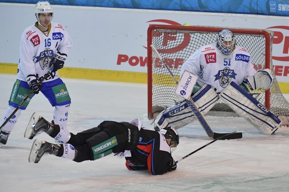 Der Fribourger Kilian Mottet, Mitte, stolpert vor die Zuger Raphael Diaz und Torhueter Tobias Stephan, von links, im Swiss Ice Hockey Cup Viertelfinalspiel zwischen dem HC Fribourg-Gotteron und dem EV ...