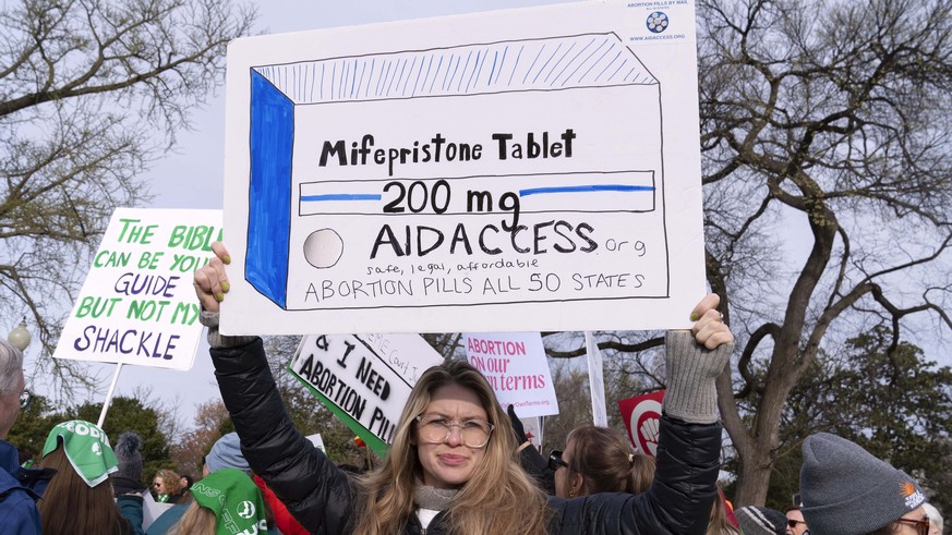 Abortion-rights activists holds a signs as they protest outside of the Supreme Court during a rally Tuesday, March 26, 2024, in Washington. Supreme Court begins hearing oral arguments in U.S. Food and ...
