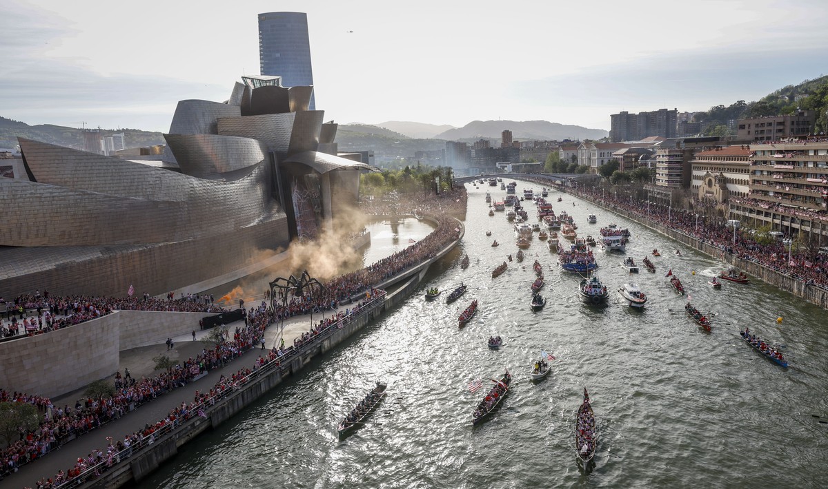 epa11273124 Dozens of boats pass by the Guggenheim Museum as they sail along Nervion estuary during the Spanish King's Cup trophy parade aboard the popular 'Gabarra' (barge), in Bilbao, ...