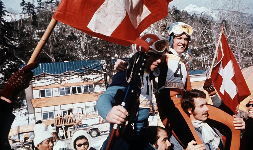 Der Schweizer Abfahrts-Olympiasieger Bernhard Russi (Nr. 4) und der Schweizer Olympiazweite Roland Collombin (Nr. 11) auf den Schultern der Fans an den Olympischen Winterspielen in Sapporo 1972. Die & ...
