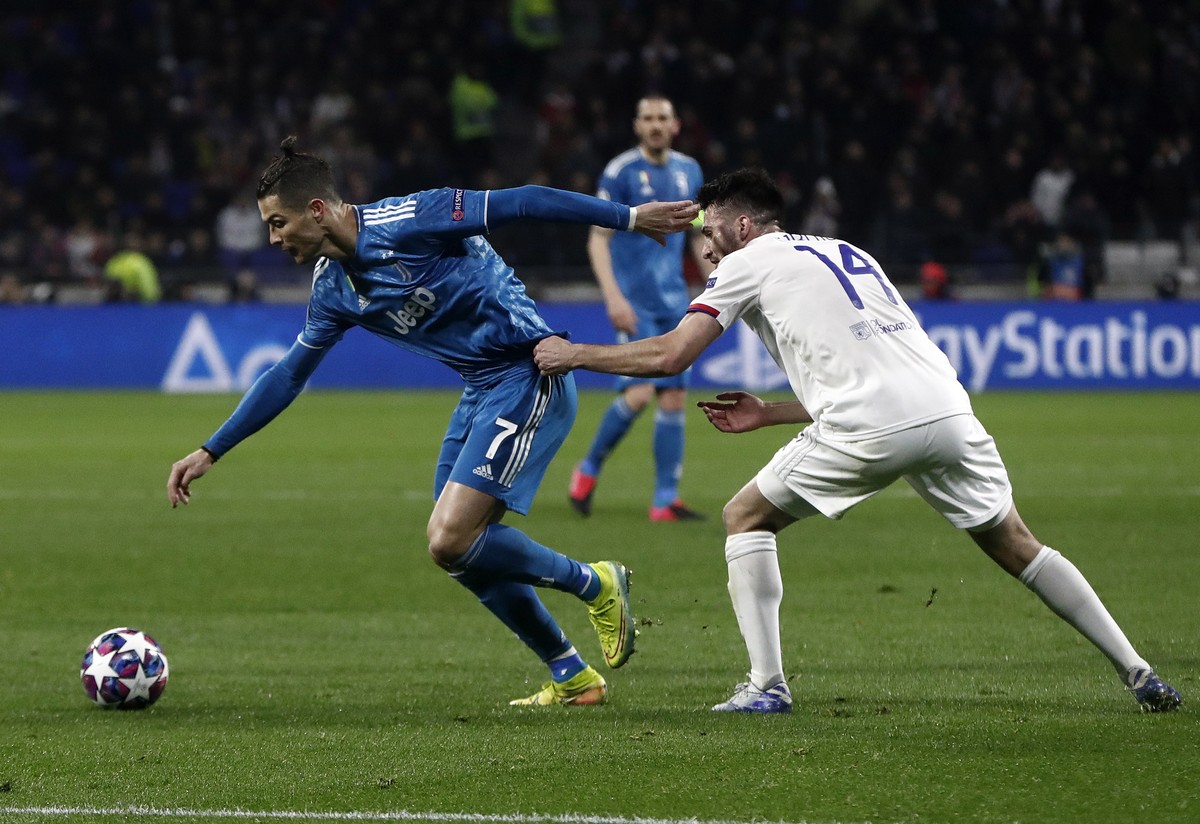 epa08250738 Cristiano Ronaldo (L) of Juventus in action against Leo Dubois (R) of Olympique Lyon during the UEFA Champions League round of 16 first leg soccer match between Olympique Lyon and Juventus ...