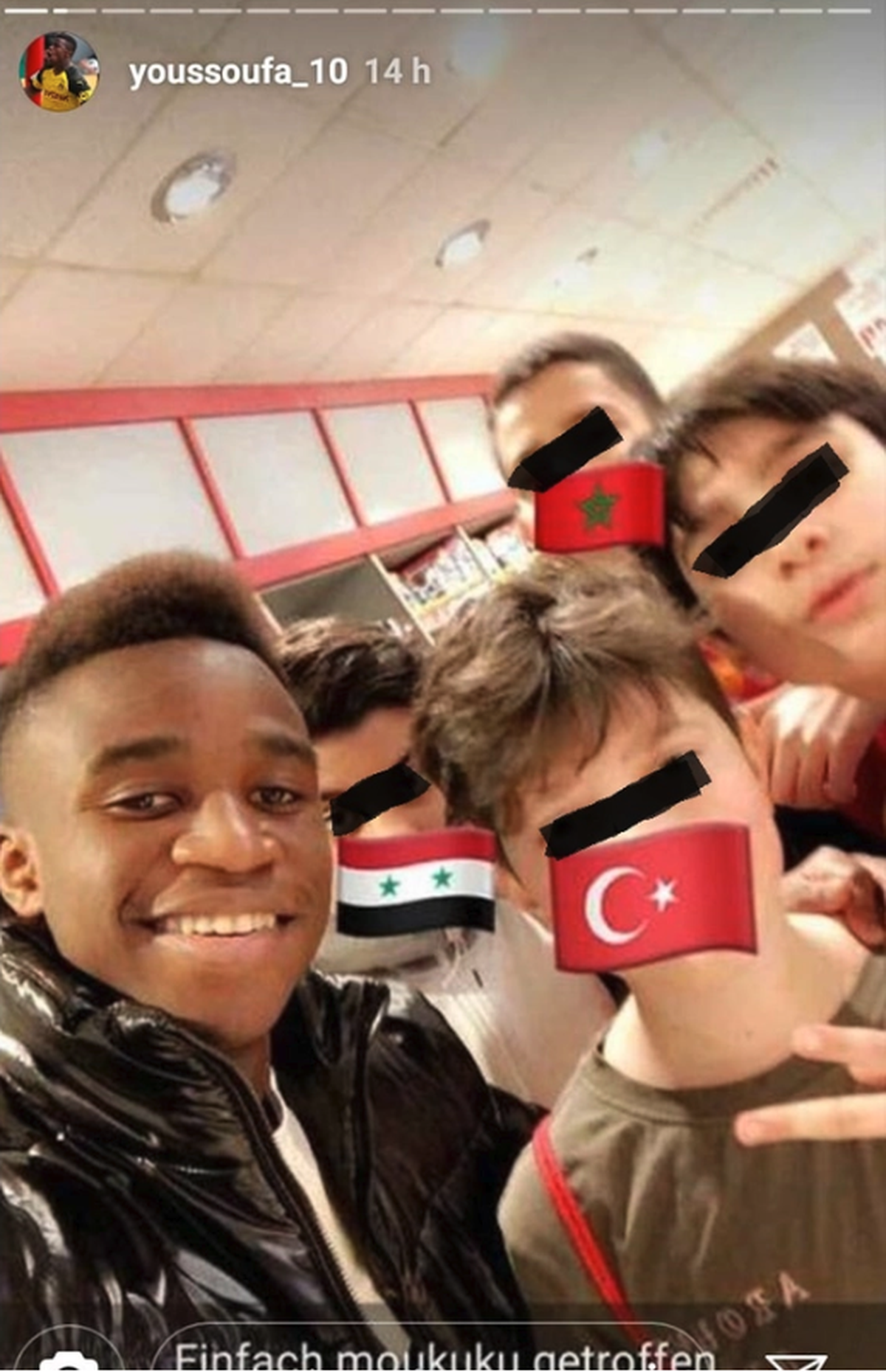 Youssoufa Moukoko posiert mit jungen Fans für ein Selfie. Die schwarzen Zensierbalken haben wir hinzugefügt.