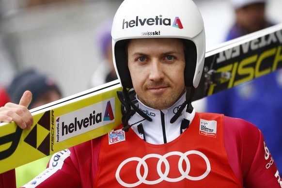 Switzerland&#039;s Simon Ammann smiles into the camera on his way to the hill at the fourth stage of the 64. four hills ski jumping tournament in Bischofshofen, Austria, Tuesday, Jan. 5, 2016. (AP Pho ...