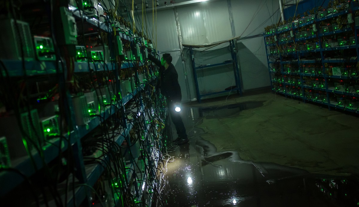 epa06062674 (03/26) Bitcoin miner Huang inspects a malfunctioning mining machine during his night shift at the Bitcoin mine in Sichuan Province, China, 26 September 2016. Miners can check a machine  ...