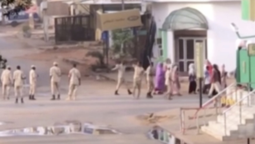 In this image made from video, Sudanese forces escort civilian in Khartoum, Sudan on Monday, June 3, 2019. Sudanese security forces moved against a protest sit-in camp in the capital Monday, witnesses ...
