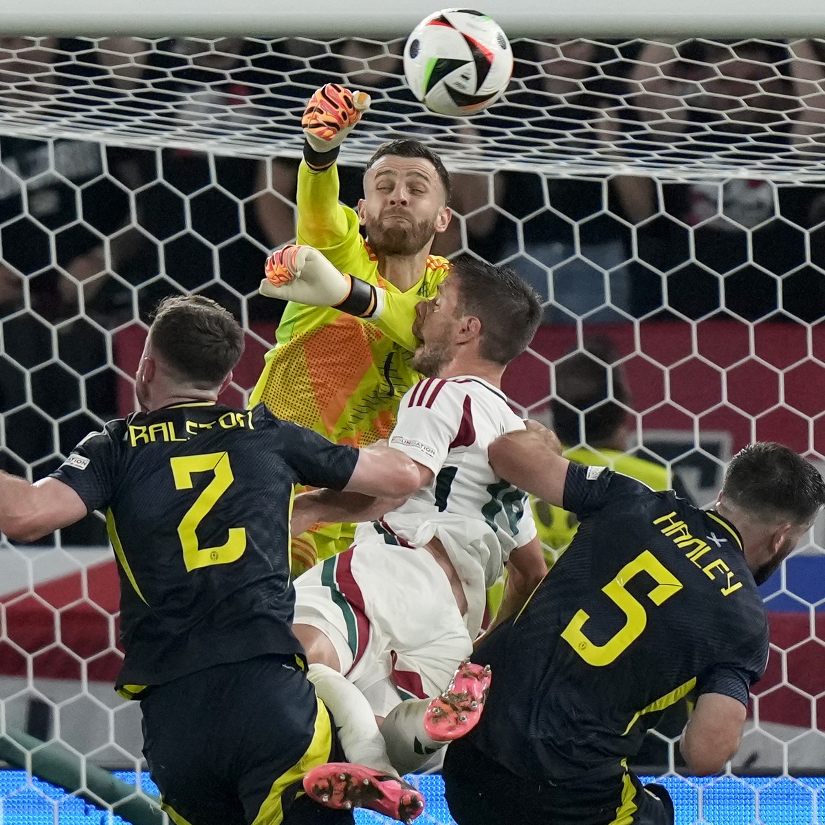 Scotland's goalkeeper Angus Gunn, up, and Hungary's Barnabas Varga, center, collide during a Group A match between Scotland and Hungary at the Euro 2024 soccer tournament in Stuttgart, Germa ...