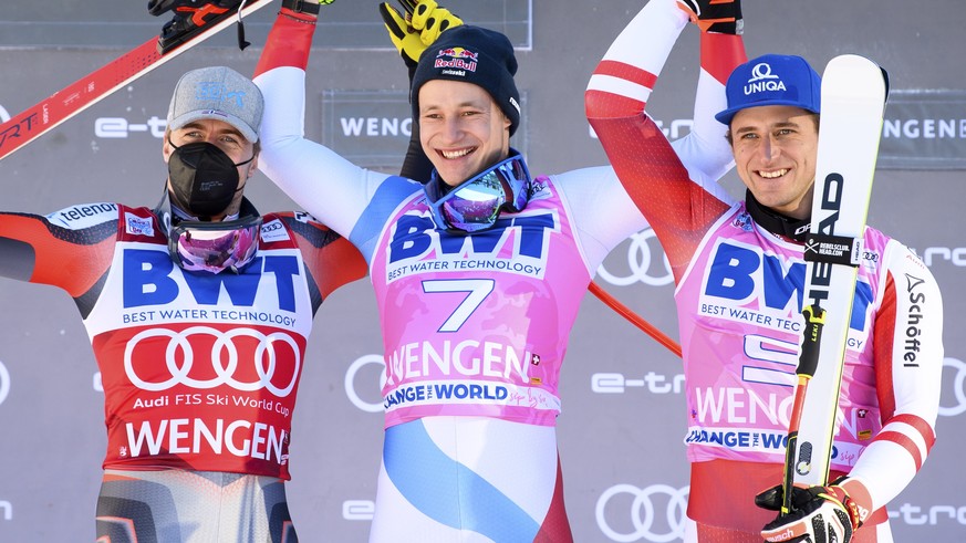 epa09682686 Marco Odermatt (C) of Switzerland celebrates on the podium after winning the men&#039;s Super G race of the FIS Alpine Skiing World Cup in Wengen, Switzerland, 13 January 2022. Odermatt wo ...