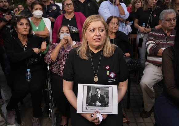 Attorney General Sandra Quinonez, holding an image of the late anti-drug prosecutor Marcelo Pecci, attends a meeting to demand justice over his murder, in Asuncion, Paraguay, Friday, May 13, 2022. The ...