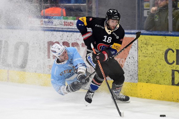 Ambri&#039;s player Alex Formenton left, fights for the puck with Fribourg&#039;s player Ryan Gunderson right, during the preliminary round game of National League (NL) Swiss Championship 2022/23 betw ...