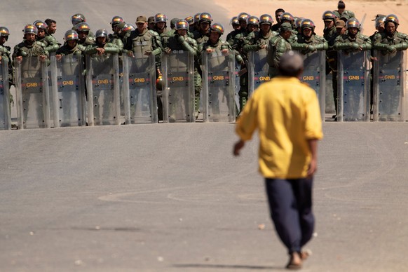 epa07393591 Members of the Bolivarian National Guard (GNB, militarized police) of Venezuela stand guard at the border crossing, in the town of Pacaraima, Brazil, 24 February 2019. EPA/JOEDSON ALVES
