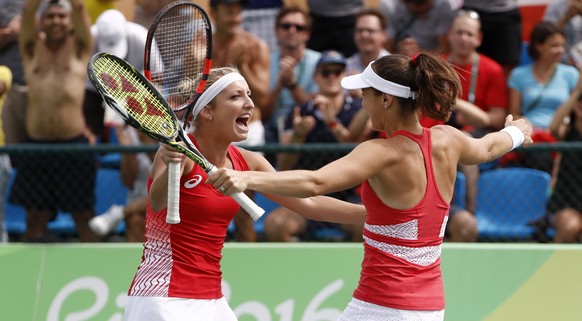 epa05465115 Timea Bacsinszky (L) and Martina Hingis of Switzerland celebrate after winning the women&#039;s second round doubles match against Bethanie Mattek-Sands and Coco Vandeweghe of USA of the R ...