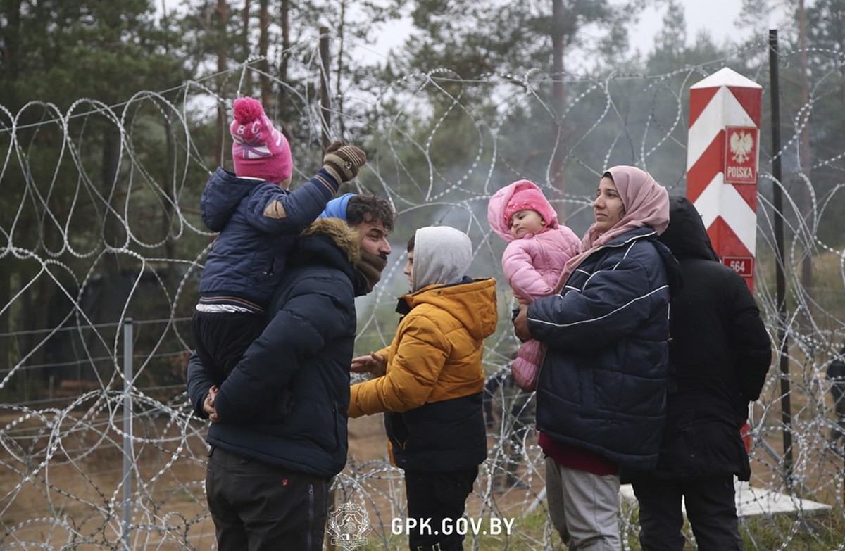 In this handout photo released by State Border Committee of the Republic of Belarus on Wednesday, Nov. 10, 2021, Migrants from the Middle East and elsewhere stand near near the barbed wire gathering a ...