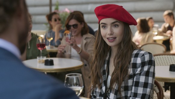 This image released by Netflix shows Lily Collins in a scene from the series &quot;Emily in Paris.&quot; The program was nominated for a Golden Globe for best musical/comedy series. Collins was also n ...